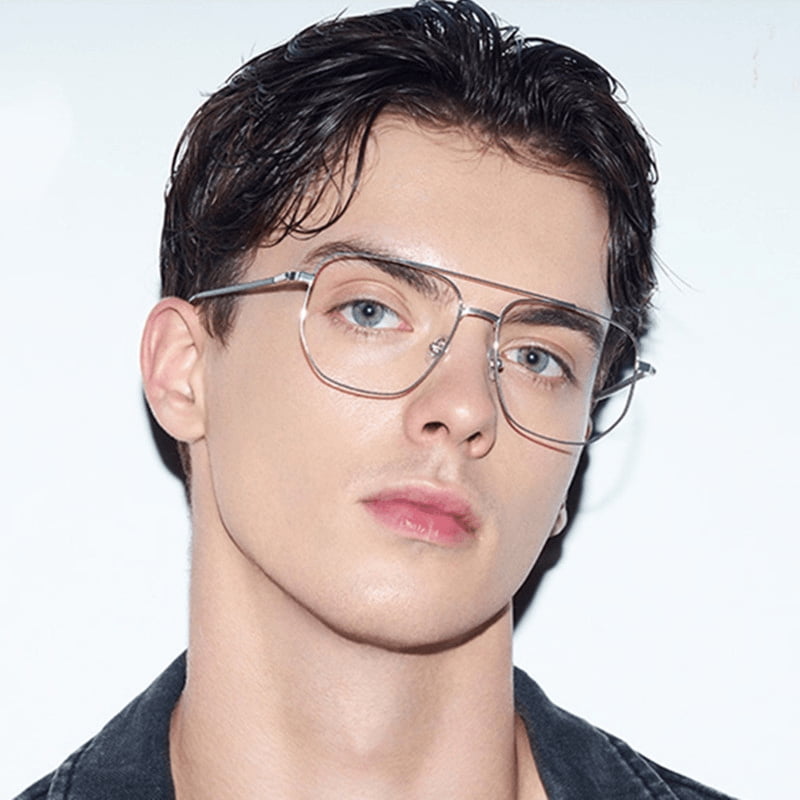 Close-up of a person wearing glasses with a plain background